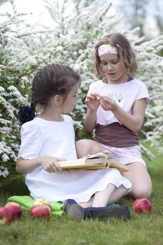 Two little girlsin spring blossom