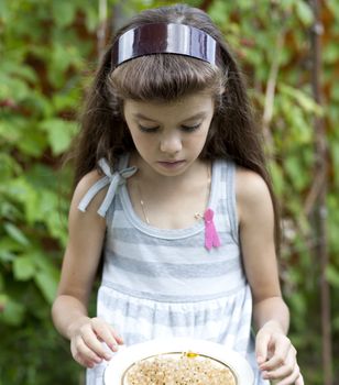 little girl holding a plate with a white currants