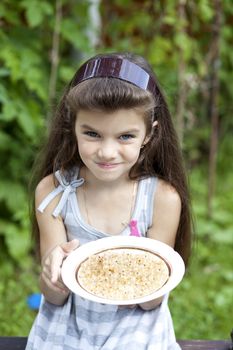 little girl holding a plate with a white currants