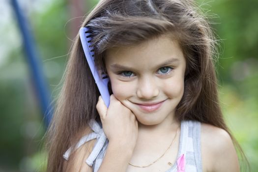 Little girl holding a comb in his hand