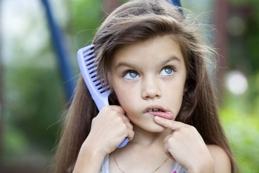 Little girl holding a comb in his hand