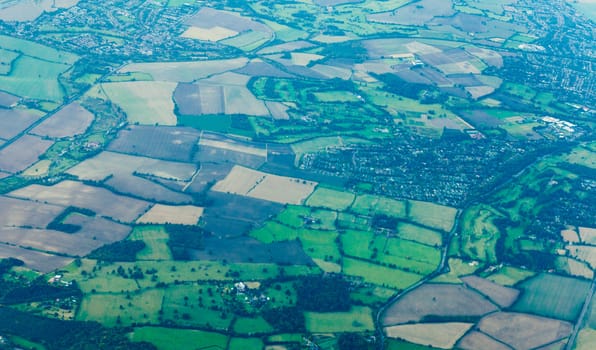 Aerial view of farmland fields pastures houses of rural villages in England UK Europe background texture pattern