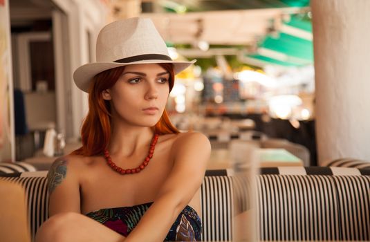 Portrait of a redhead girl in casual outfit in bar 