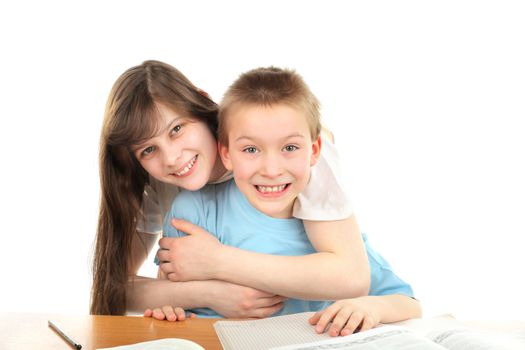 happy brother and sister on the table with exercise books
