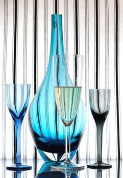 Glass of champagne, liqueur glasses and decanter