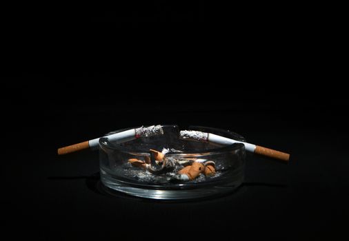 Dirty Ashtray And Two Cigarette On the Dark Background