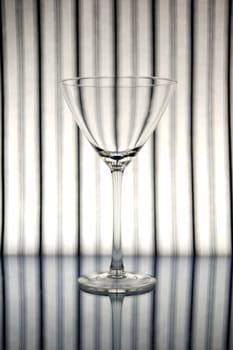 Cocktail glass in front of striped background