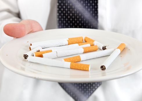 Man Holding Plate with Many Cigarettes closeup. Isolated on the white background