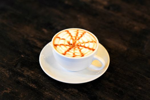 Cappuccino coffee over wooden table