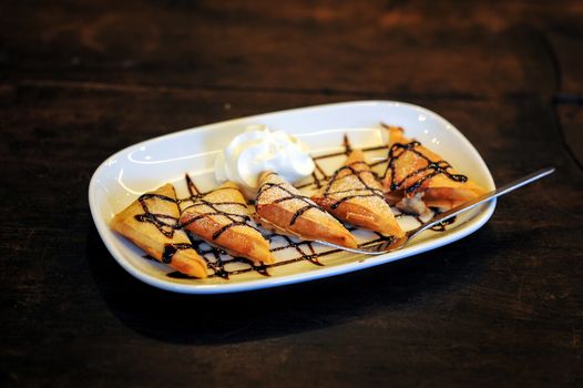 Delicious fried crepe with banana filling with chocolate sauce