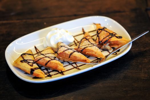 Delicious fried crepe with banana filling with chocolate sauce