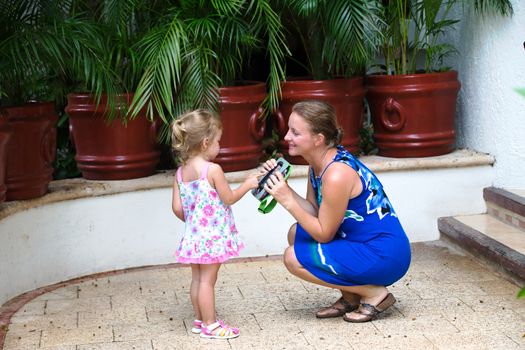 mother and daughter interacting in front of house