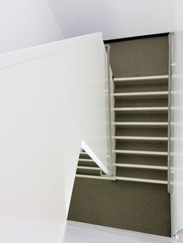 Staircase inside modern residential apartment building in high-angle view as an architectural abstract background.