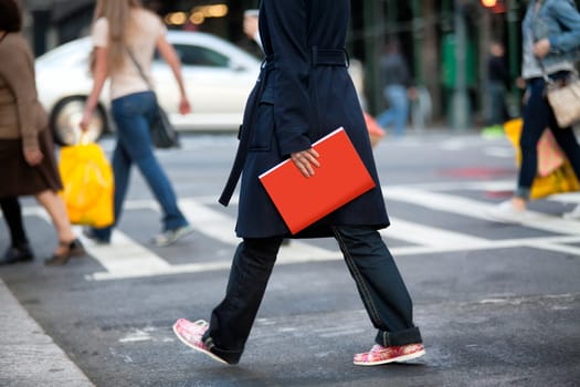 Girl walking on the street and holding red book.