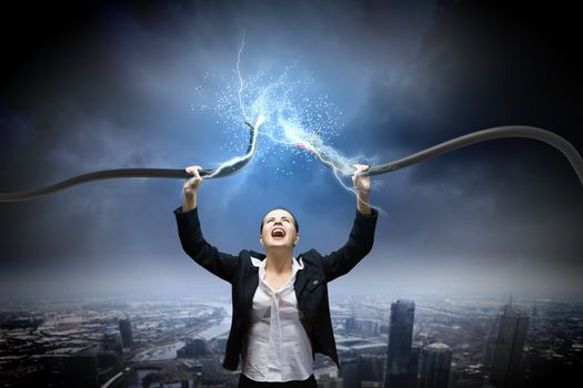 Image of businesswoman holding electrical cable above head