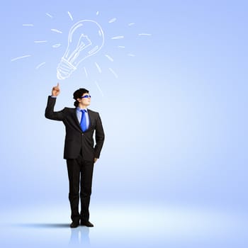 Image of young businessman with light bulb. New idea and inspiration