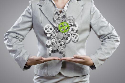 Close up image of businesswoman holding gears in hands