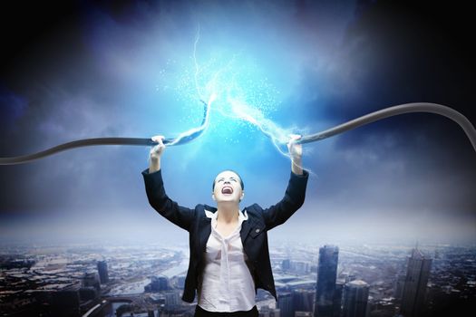 Image of businesswoman holding electrical cable above head