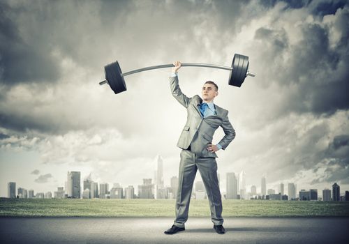 Image of strong businessman lifting barbell above head with one hand