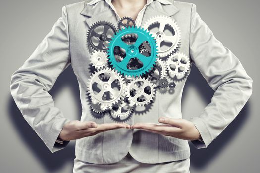 Close up image of businesswoman holding gears in hands