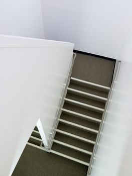 Staircase inside modern residential apartment building in high-angle view as an architectural abstract background.