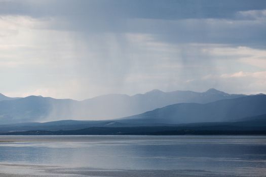 Heavy rain shower over Marsh Lake Yukon Territory Canada and distant mountain range