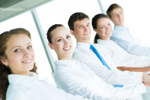 young business people holding hands, standing in a row, the concept of teamwork