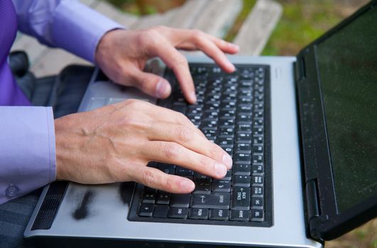 male hands typing on a laptop keyboard