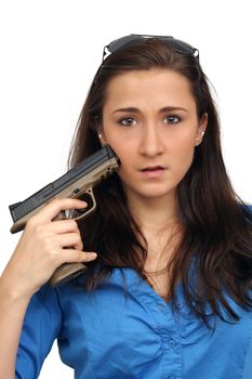 A lovely young brunette points a modern handgun at herself.  Isolated on a white background with generous copyspace.