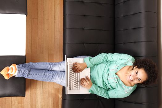 A young, brazilian woman surfing on the Internet with a Laptop.  