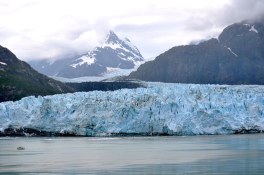  Alaskan Glacier overshadows boat on water
