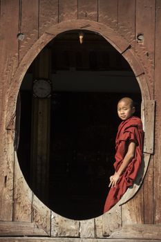 Young novice monk enjoys the morning sun at Shwe Yaunghwe Kyaung Monastery at Nyaungshwe near Inle Lake in Shan State in central Myanmar (Burma).