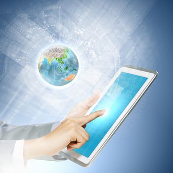 Close up image of human hand touching screen of tablet pc. Elements of this image are furnished by NASA