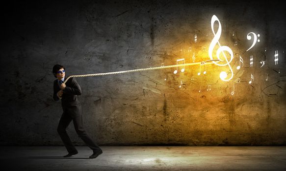 Image of young man pulling clef with rope