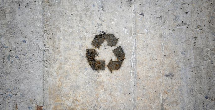 Grey stone wall with recycling symbol. Ecology idea