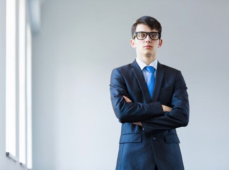 Image of handsome businessman in glasses with arms crossed on chest