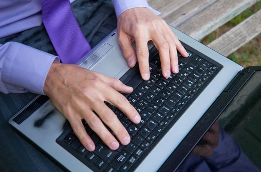 male hands typing on a laptop keyboard