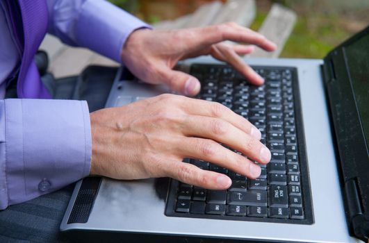 male hands typing on a laptop keyboard