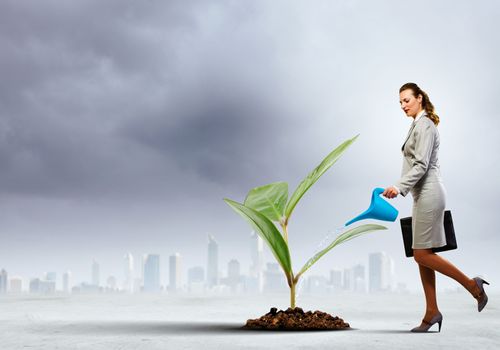 Image of businesswoman watering tree with pot. Ecology concept