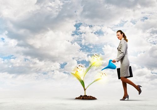 Image of businesswoman watering money tree with pot