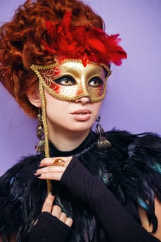 Close-up portrait of red-haired woman hides her face behind a mask