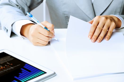 Image of businesswoman sitting at table and drawing sketch