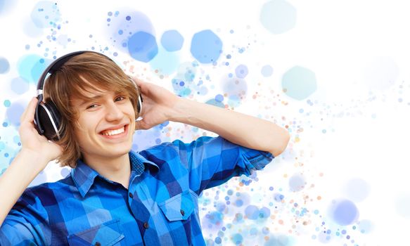 Happy smiling young man dancing and listening to music