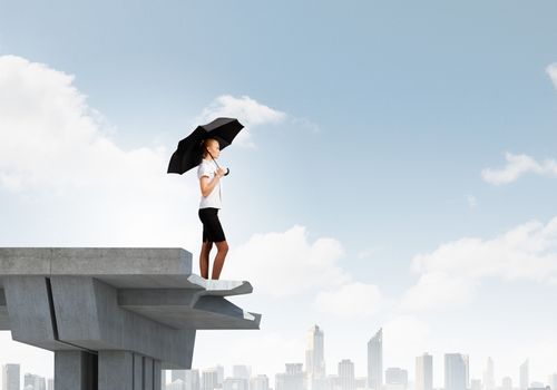 Image of businesswoman standing at the edge of bridge. Risk concept