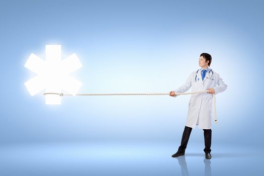 Image of male doctor pulling health sign with rope