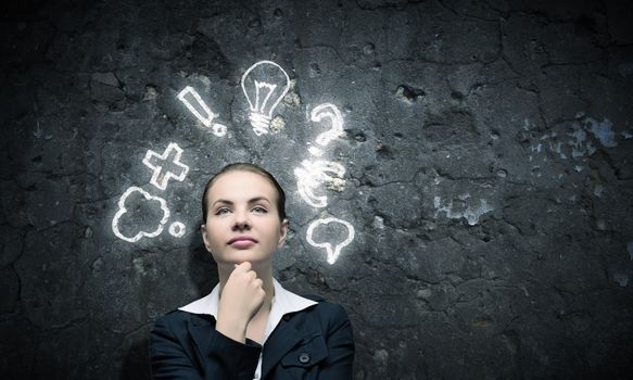 Image of thoughtful businesswoman looking at light bulb