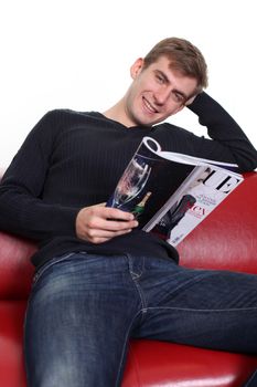 young man with magazine sitting on sofa