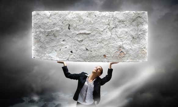 Image of young businesswoman holding burden above head