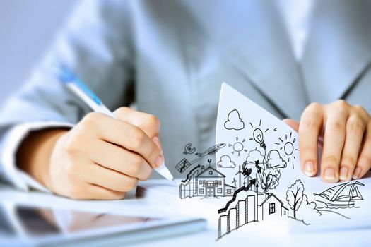 Image of businesswoman sitting at table and drawing sketch