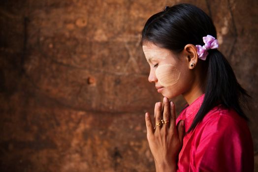 Beautiful traditional Myanmar girl in a praying pose.